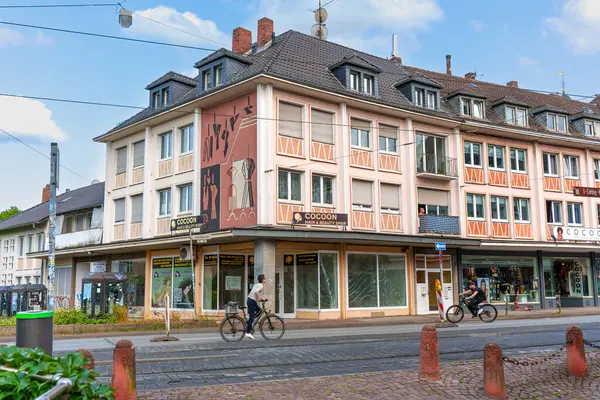 Darmstadt, Almanya - 5 Haziran 2025: Gündüz Darmstadt 'ta canlı bir cadde boyunca dekoratif bir cephe, parketmiş bisikletler ve yayalar içeren büyüleyici mimari.
