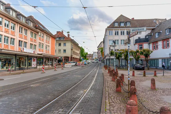 Darmstadt, Almanya - 5 Haziran 2025: Darmstadt kentsel caddesi, tramvay rayları, tarihi binalar ve parçalı bulutlu bir gökyüzü altında canlı vitrinler.