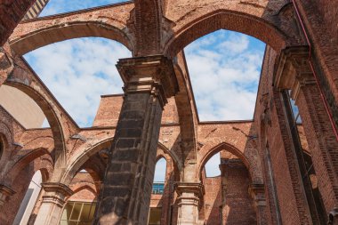 Köln, Almanya - 15 Haziran 2025: Köln 'deki Alt St. Alban kilise kalıntılarının karmaşık mimari detayları, yükselen kemerler ve parlak gökyüzüne karşı eskimiş tuğlalar.