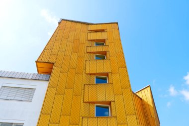Berlin, Almanya - 16 Ağustos 2025: Berliner Filarmoni Orkestrası 'nın belirgin sarı cephesi, modern geometrik modeller, büyük pencereler ve canlı mavi gökyüzü arkaplanı.