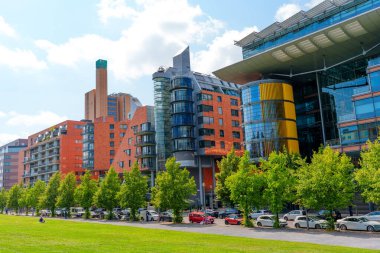 Berlin, Almanya - 16 Ağustos 2025: Daimler City kompleksi, Potsdamer Platz, Berlin 'de günışığı altında yenilikçi tasarım elementleri ve yeşil alanlar içeren çağdaş binalar.