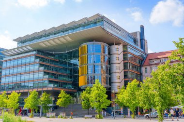 Berlin, Almanya - 16 Ağustos 2025: Berlin 'deki Linkstrasse 6 Binası, modern tasarım, cam cepheler ve açık mavi gökyüzü altında canlı sarı aksanlar.