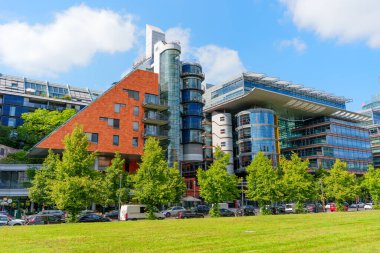 Berlin, Almanya - 16 Ağustos 2025: DaimlerChrysler kompleksinin etkileyici modern mimarisi Berlin 'de açık mavi gökyüzü altında cam ve tuğla yapılar.