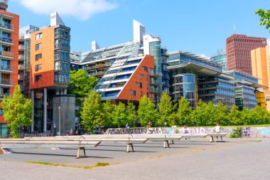 Berlin, Almanya - 16 Ağustos 2025: Berlin 'de yeşilliklerle çevrili eşsiz geometrik tasarımlara sahip çağdaş binalar.