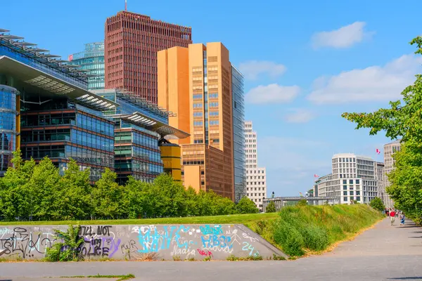 Berlin, Almanya - 16 Ağustos 2025: Çağdaş binalar, kentsel yeşillik ve yol boyunca sokak sanatının yer aldığı Berlin şehri.