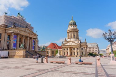 Berlin, Almanya - 16 Ağustos 2025: Konser Evi, Fransız Katedrali ve canlı mavi gökyüzünün yer aldığı Jandarma Meydanı 'nın mimari görünümü.