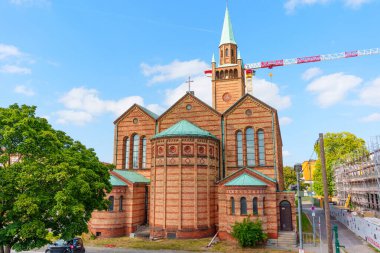 Berlin, Almanya - 16 Ağustos 2025: Berlin 'deki St. Matthew Kilisesi' nin dış görünüşü, açık mavi gökyüzünün altında eşsiz kırmızı tuğla yapısını ve yüksek kulesini sergiliyor.