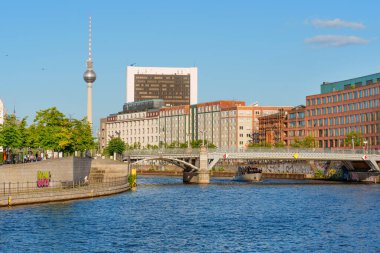 Berlin, Almanya - 16 Ağustos 2025: Berlin 'deki Spree Nehri' nin manzarası, Berlin TV Kulesi ve banka boyunca uzanan modern mimarinin manzarası.