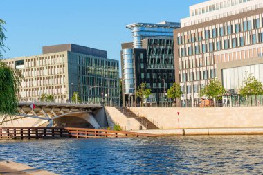 Berlin, Almanya - 16 Ağustos 2025: Spree Nehri çağdaş binalar, cam cepheler ve kentsel tasarım sergileniyor.