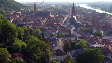 Heidelberg 'in Eski Kasabası' nın havadan görünüşü ve sabah sıcacık ışıklarıyla yıkanan bir kilise çatıları ve manzaralı nehir manzarası..