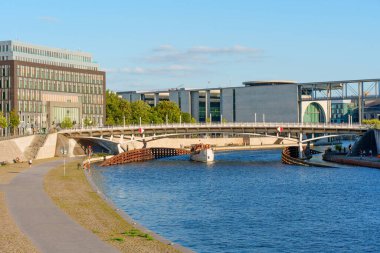 Berlin, Almanya - 16 Ağustos 2025: Spree Nehri üzerindeki bir köprünün ayrıntılı görünümü, modern Berlin mimarisinin arka plandaki sahneyi çerçevelemesi.