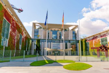 Berlin, Almanya - 17 Ağustos 2025: Bayraklar ve çağdaş mimari unsurların yer aldığı Alman Başbakanlık cephesine yakından bakmak.