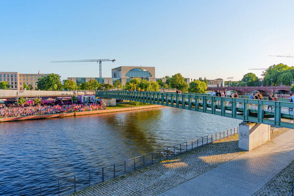 Берлин, Германия - 16 августа 2025 года: Часто посещаемый мост через реку Шпрее в Берлине, демонстрирующий толпу, наслаждающуюся событиями вдоль берегов реки.