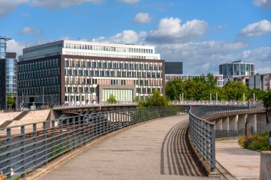 Berlin, Almanya - 17 Ağustos 2025: Açık mavi bir gökyüzü altında Berlin, Almanya 'da yeşillik ve şehir manzarasıyla çevrili Federal Basın Konferansı Evi' nin mimari görüşü.