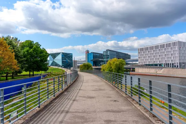 Berlin, Almanya - 17 Ağustos 2025: Berlin 'de çağdaş binalar ve yemyeşil yeşilliklerin yer aldığı Spree Nehri' nin yanındaki patika.