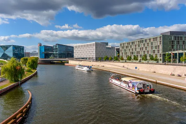 Berlin, Almanya - 17 Ağustos 2025: Berlin, Almanya 'da tekne turları ve çağdaş binaların yer aldığı River Spree' nin canlı görüntüsü.