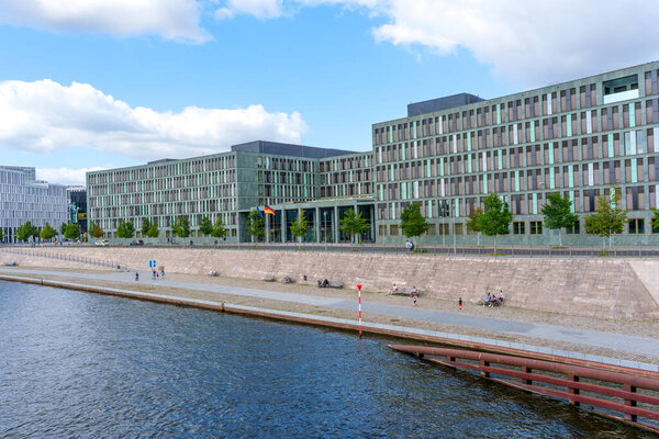 Берлин, Германия - 17 августа 2025 года: Современное правительственное здание Федерального министерства образования и исследований в Берлине, с гладкими линиями, зелеными элементами и видом на набережную.