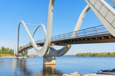 Kyiv 'in Obolon Adası' ndaki dalga yayası köprüsü su üzerinde çarpıcı bir mimari manzara sunuyor, geniş açı..