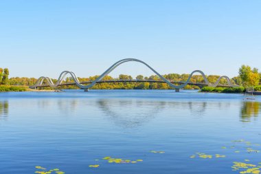 Dalga Köprüsü 'nün nefes kesici manzarası Kyiv' deki Obolon Adası 'nın sakin sularını yansıtıyor..