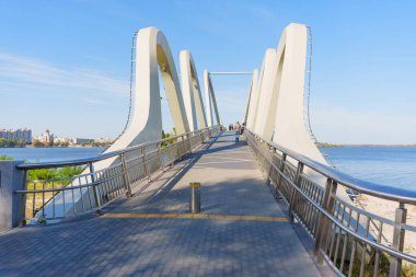 Kyiv, Ukrayna - 23 Eylül 2025: Wave Köprüsü 'nde yürüyen ve Kyiv' deki çarpıcı şehir manzarasının ve nehir manzarasının tadını çıkaran bireylerin canlı sahnesi.