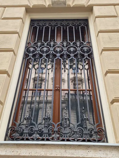 Retro style window with wrought iron grille with reflection