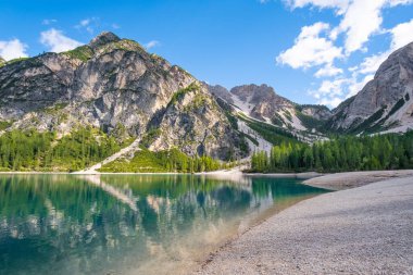 Dolomitlerdeki Braies Gölü 'nde bulutlar suya yansıyor.