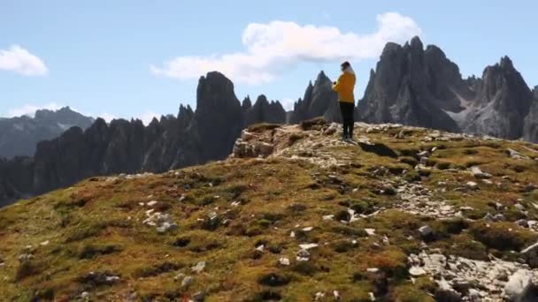 女性旅行者は Tre Cime Lavaredoの近くの山の風景で双眼鏡を見ています 空中渓谷の眺めの近くの山の上に立つ観光客 — ストック動画
