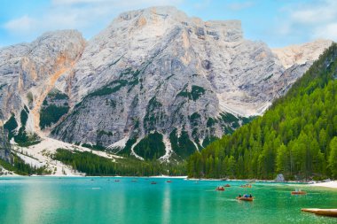 Braies Gölü ya da Braies Lago di Braies 'in ahşap botlara binen turistlerle muhteşem manzarası. Alp gölündeki gölde eğlence.. 