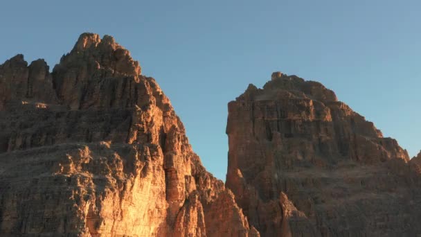 美丽的拉瓦雷多三峰的尖脸在晴朗的蓝天下被升起的太阳照亮着 日出鸟瞰壮丽的无地山峰景观 — 图库视频影像