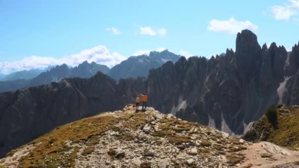 男性の観光地の地平線に手 双眼鏡を通してラバレドの3つのピークの山岳風景を見る女性旅行者 — ストック動画