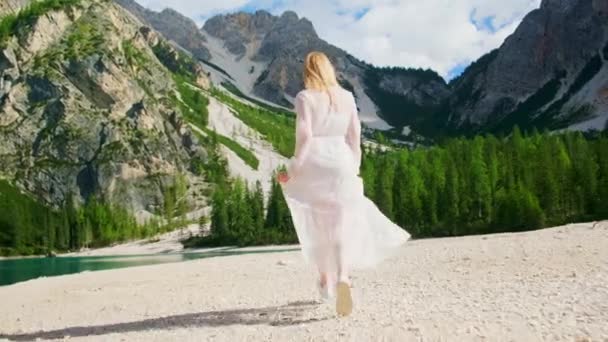 Mujer Rubia Vestido Blanco Largo Corre Lago Braies Rodeado Montañas — Vídeos de Stock