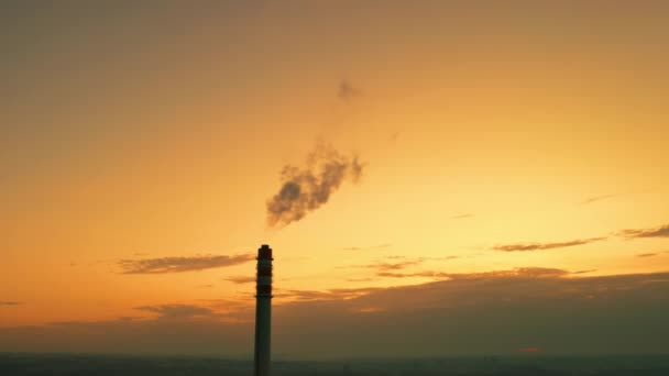 发电厂的烟囱向环境中排放有害的空气 工厂塔楼冒出的有毒烟雾在橙色落日的天空中形成了黑暗的烟雾 — 图库视频影像
