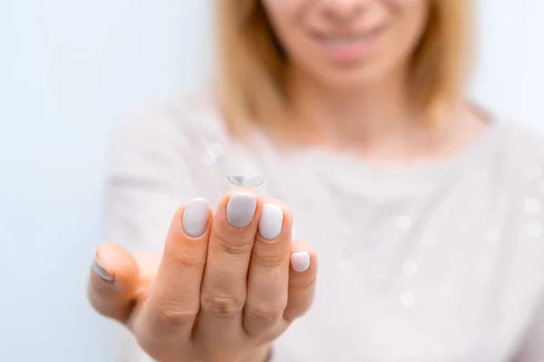 Contact eye lens on the tip of the finger. Eye health care concept.