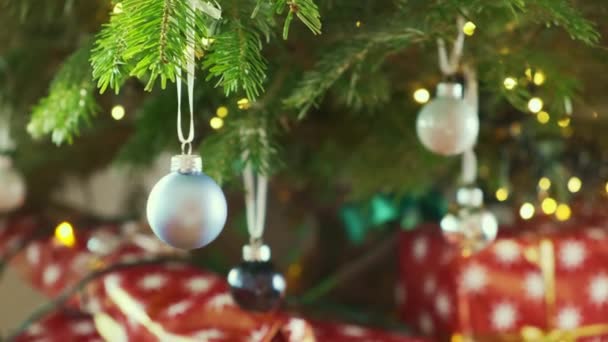 Blue Ball Sways Christmas Tree Shining Background Wrapped Gifts — Stock Video