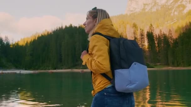 日落时分 女性游客在布雷湖畔散步 望着巨大的高山和森林 背着背包的女徒步旅行者喜欢野性慢动作 — 图库视频影像