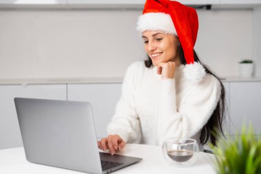 Genç beyaz kadın Noel 'den önce evde uzaktan çalışıyor. Bir kadının evinde bir video görüşmesi var.. 