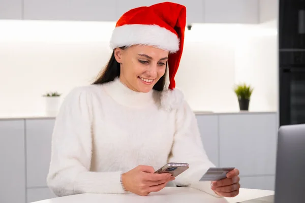 Szczęśliwa Kobieta Czerwonym Kapeluszu Świętego Mikołaja Używa Karty Kredytowej Smartfona — Zdjęcie stockowe