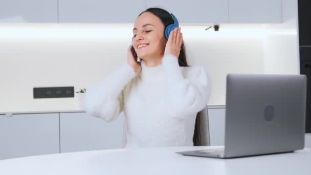 Positive Young Woman Listens Music Enthusiastically Using Modern Wireless Headphones — Stockvideo