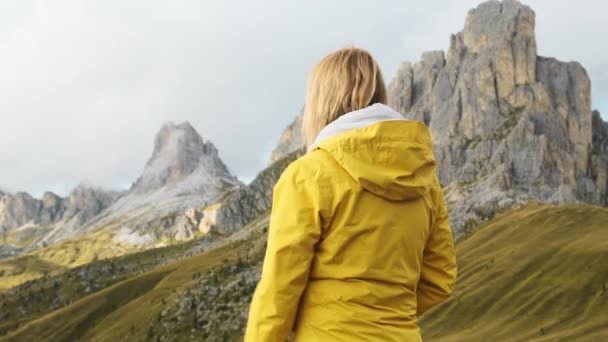 好奇的女人指着帕索乔的岩石山走过 年轻的黄石公园徒步旅行者欣赏意大利阿尔卑斯山背面的慢镜头 — 图库视频影像