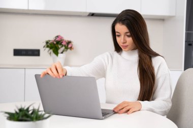 Young smiling student freelancer using a computer for remote work or e-learning at the university.