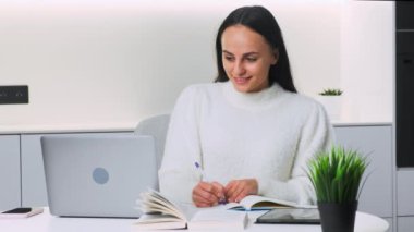 Sınavlara hazırlanan ve online ders izleyen odaklanmış genç bir üniversite öğrencisi..