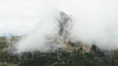 Giau geçidi yakınlarındaki yüksek dağda hafif sisli bulutlar gri gökyüzüne ulaşır. Otlaklar için yeşil çayırları olan Alp Dağı vadisi