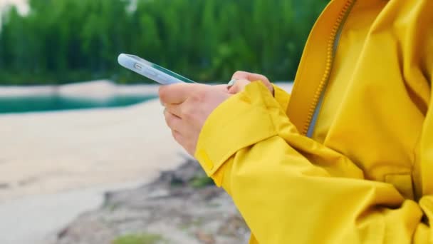 Γυναίκα Χρησιμοποιεί Ένα Smartphone Στέκεται Κοντά Στη Λίμνη Τουρίστας Μοιράζεται — Αρχείο Βίντεο