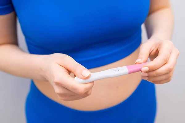 Top view on a positive pregnancy test in woman hands.