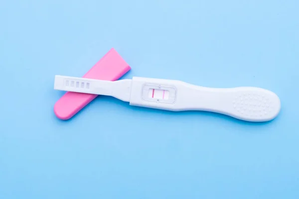 Positive pregnancy test on a blue background. Happy motherhood