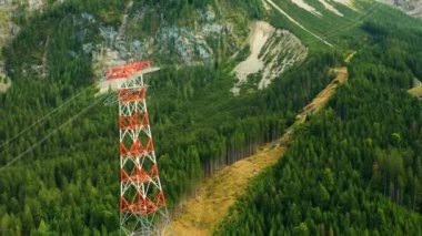 Dağlardaki yüksek voltajlı elektrik iletim kulesi ağaçlarla çevrili, hava manzaralı.