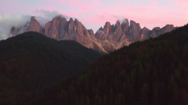 Odle ya da Geisler Dolomitleri 'nin pembe günbatımındaki güzel kitlesinin hava manzarası.