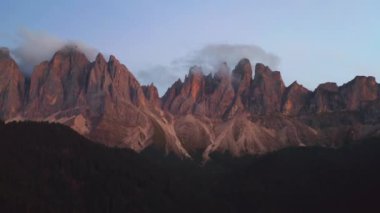 Santa Maddalena köyünde bulutlarla kaplı dolomitlerin hava manzarası inanılmaz günbatımında.