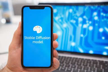 Cep telefonu ekranında sabit difüzyon modeli yapay zeka logosu ve arka plandaki dizüstü bilgisayar ekranında, Mart 2023, Prag, Çek Cumhuriyeti.