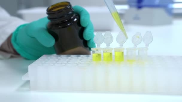 Cientista Luvas Borracha Derrama Líquido Amarelo Tubos Ensaio Plástico Com — Vídeo de Stock